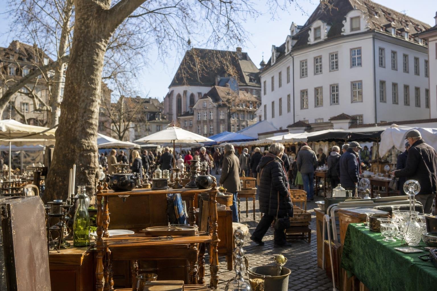 shoppers browsing antique and vintage market stalls at Barfüsserplatz Flohmarkt in Switzerland