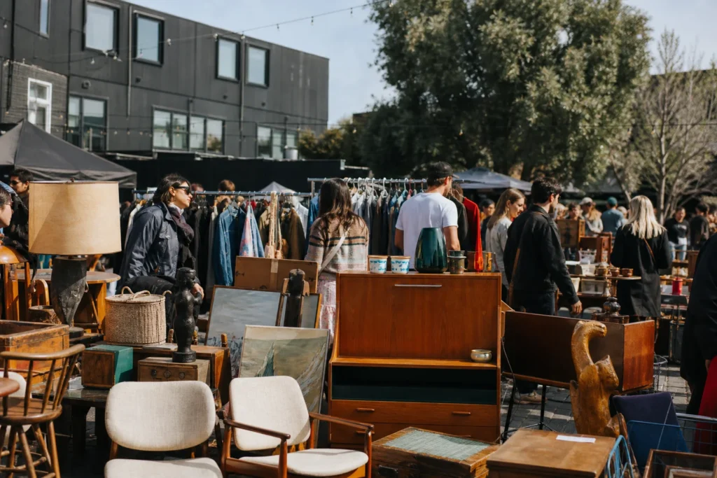 shoppers browsing antique and vintage market stalls at Brunswick Community Flea Market in Melbourne, Victoria