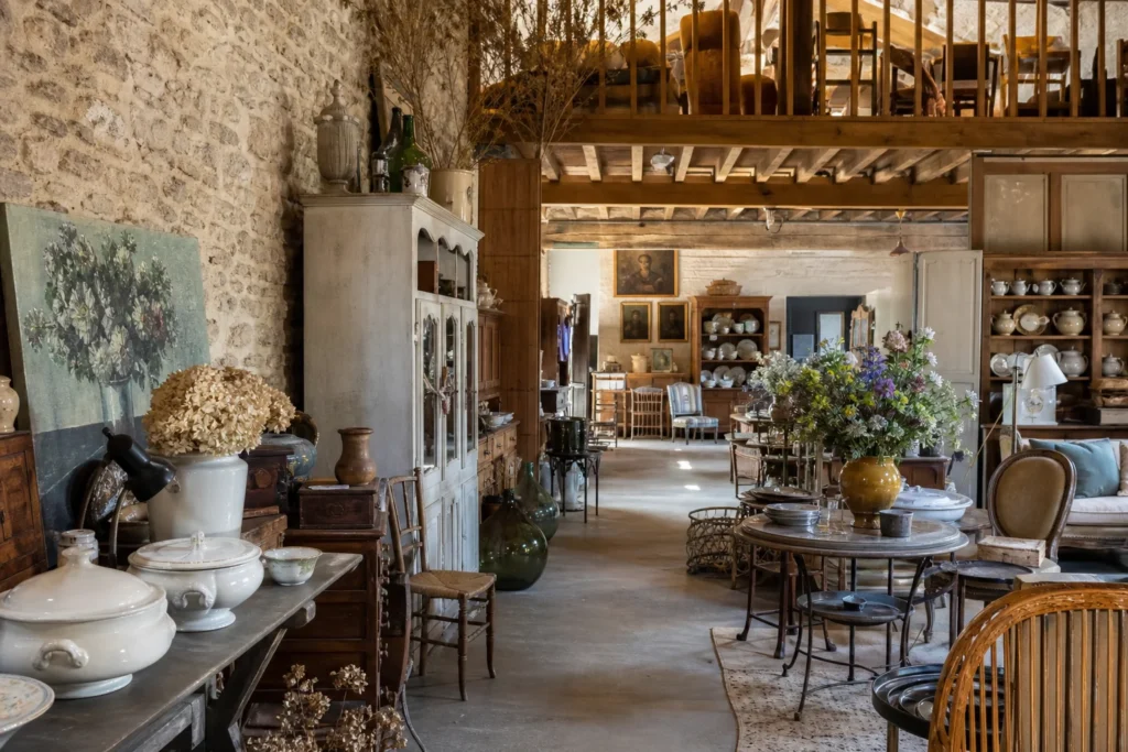 shoppers browsing antique and vintage market stalls at Les Puces du Moulin in France