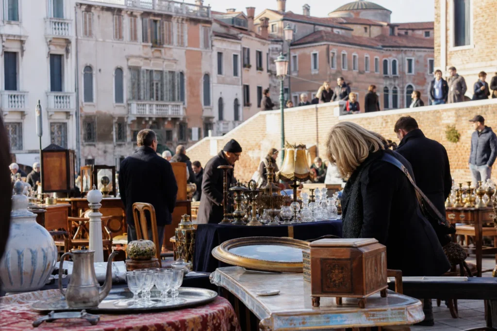 shoppers browsing antique and vintage market stalls at Mercatino Antiquariato Campo San Maurizio in Italy