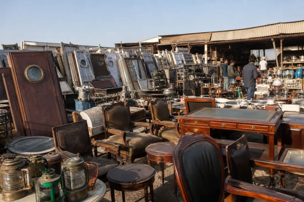 shoppers browsing antique and vintage market stalls at Alang Shipyard Market in India