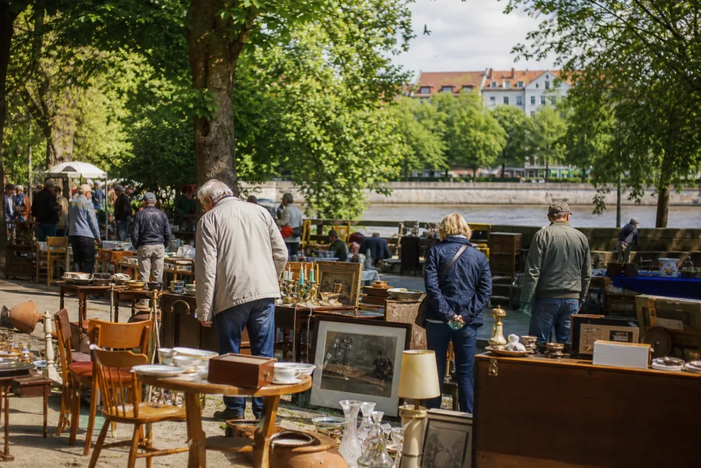 shoppers browsing antique and vintage market stalls at Altstadt-Flohmarkt am Hohen Ufer in Germany