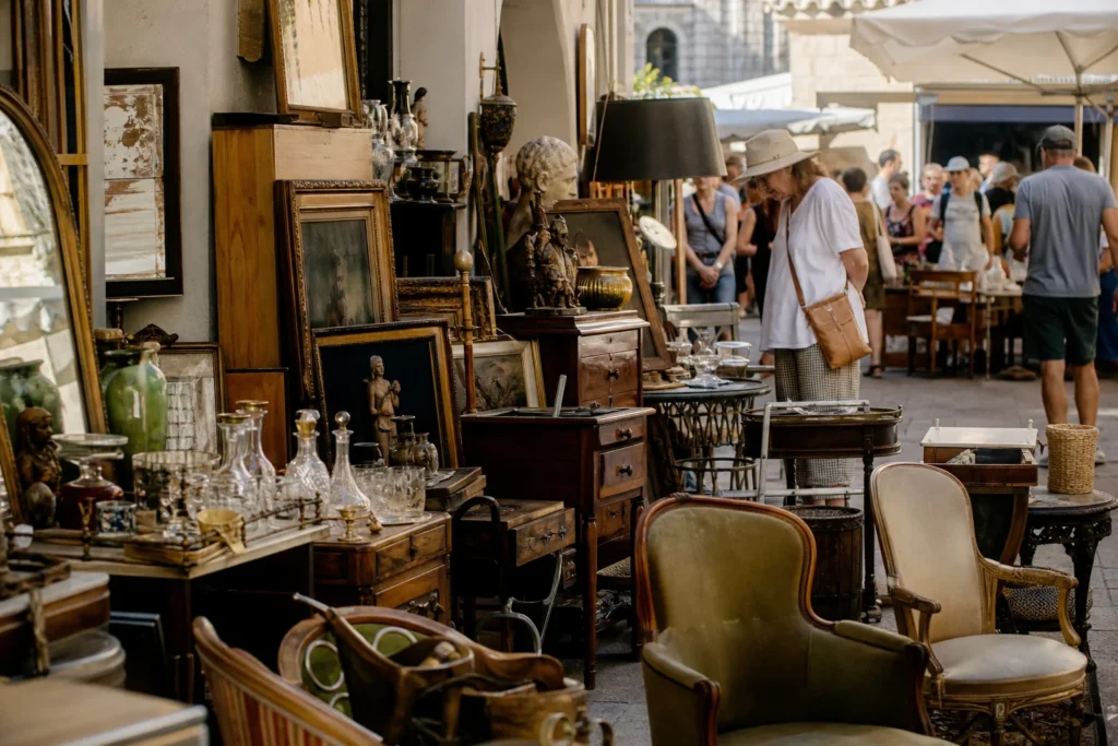 shoppers browsing antique and vintage market stalls at Antibes Antiquités & Brocante in France, Provence
