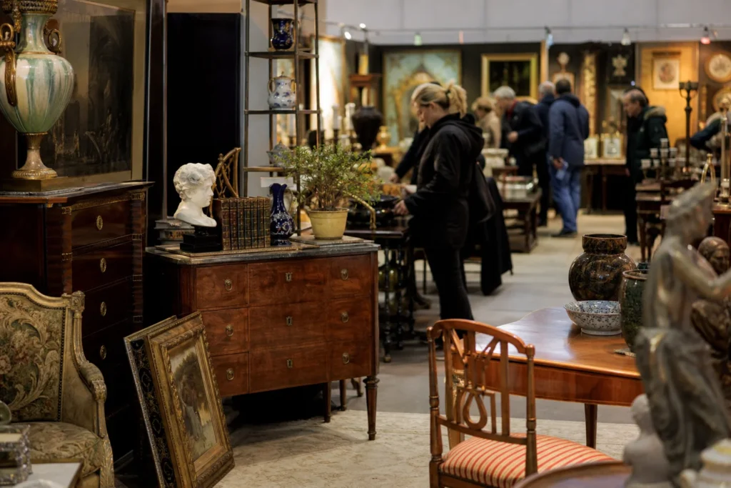 shoppers browsing antique and vintage market stalls at Antikmässan in Sweden