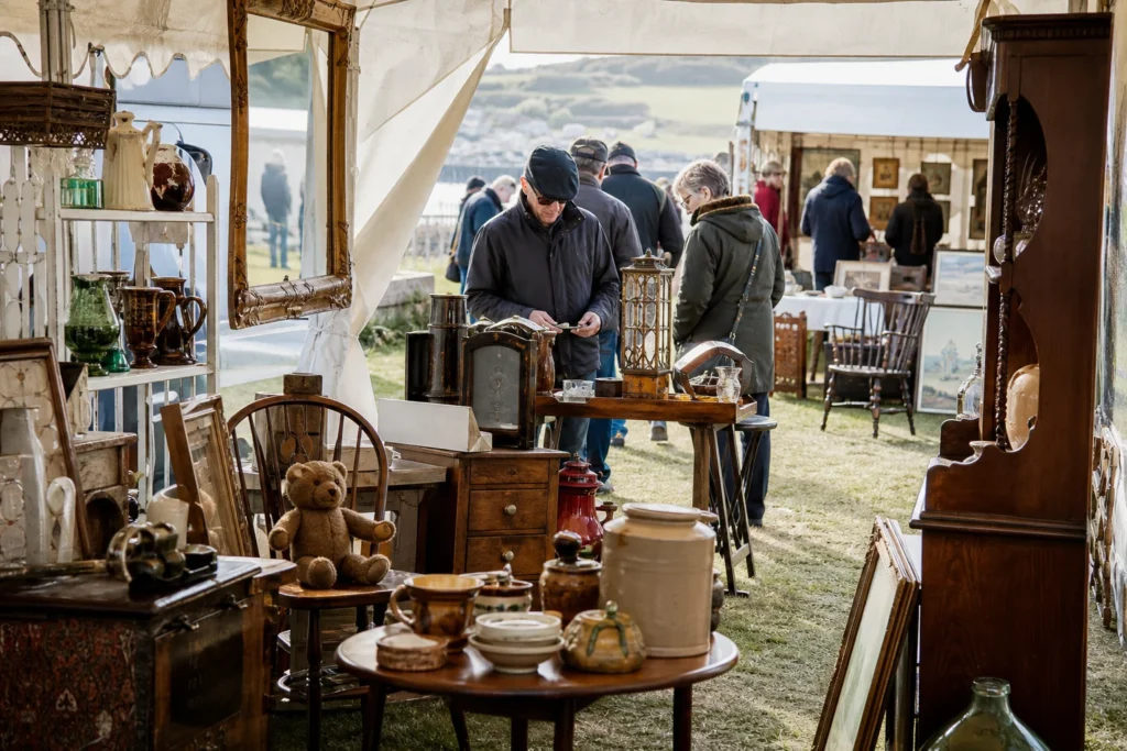 shoppers browsing antique and vintage market stalls at Antique Fairs Cornwall in United Kingdom