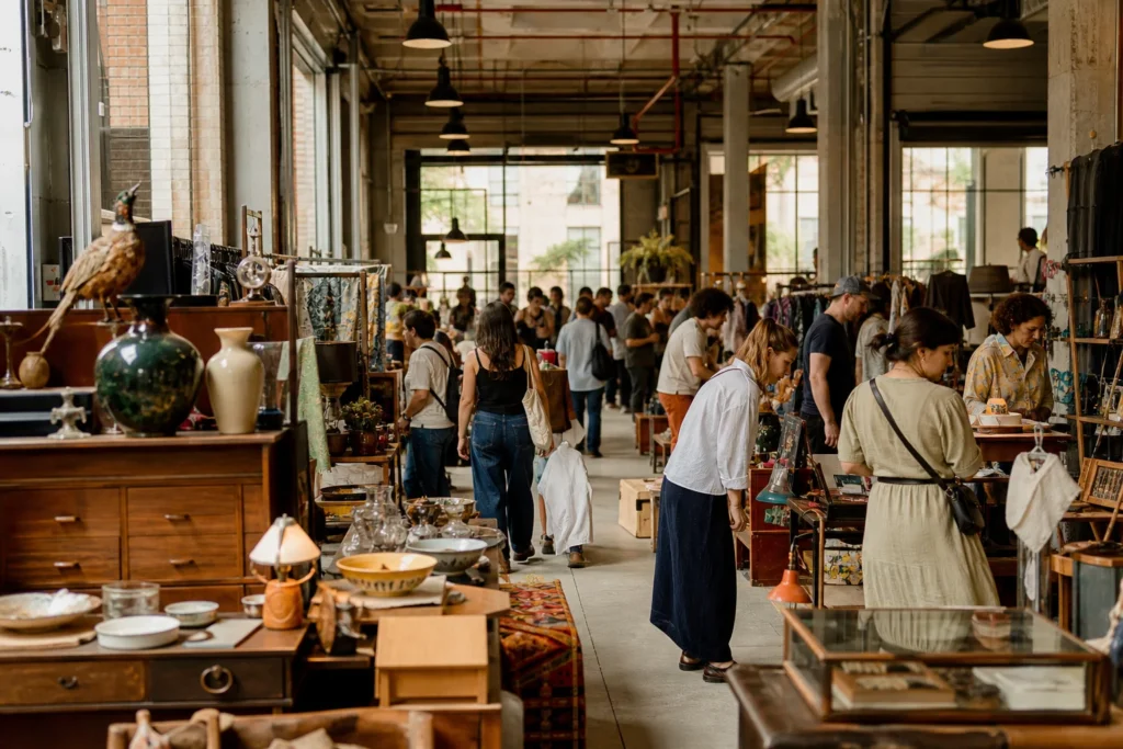 shoppers browsing antique and vintage market stalls at Artists & Fleas Williamsburg in New York City, New York State