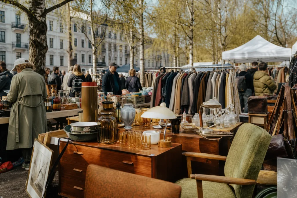 shoppers browsing antique and vintage market stalls at Birkelunden Marked in Norway