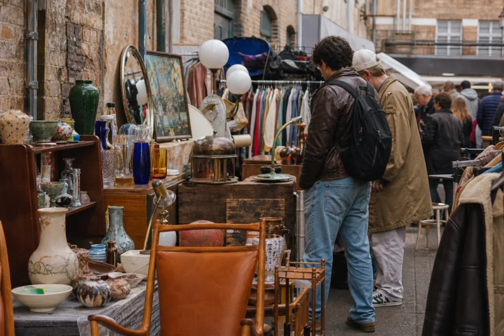shoppers browsing antique and vintage market stalls at Brick Lane Market in London