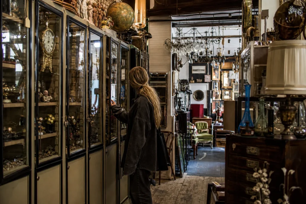 shoppers browsing antique and vintage market stalls at Brighton Flea Market in United Kingdom