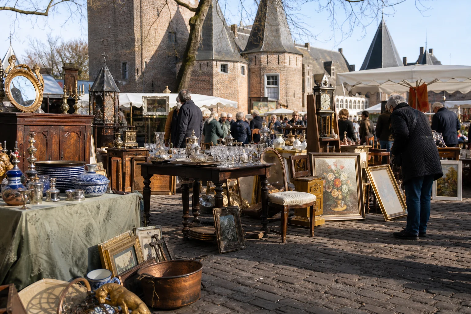 shoppers browsing antique and vintage market stalls at Brocante Markt Heusden in Netherlands