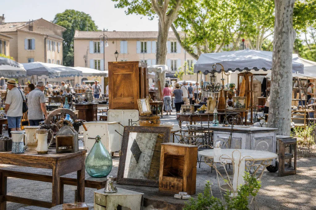 shoppers browsing antique and vintage market stalls at Carpentras flea market in Provence