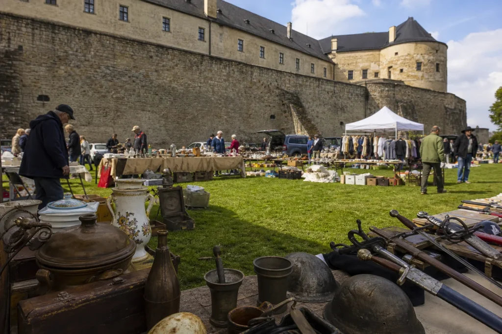 shoppers browsing antique and vintage market stalls at Červený Kameň Flea Market in Slovakia