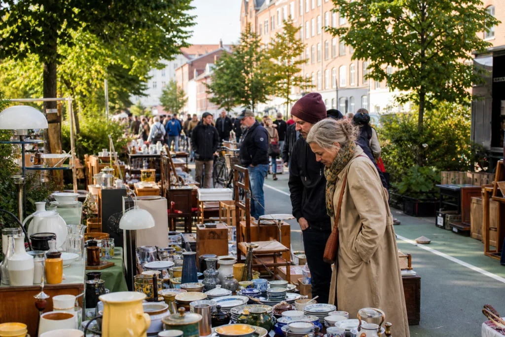 shoppers browsing antique and vintage market stalls at Det Grønne Loppemarked in Copenhagen