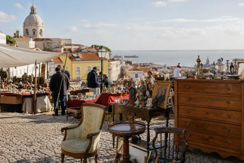 shoppers browsing antique and vintage market stalls at Feira da Ladra in Portugal