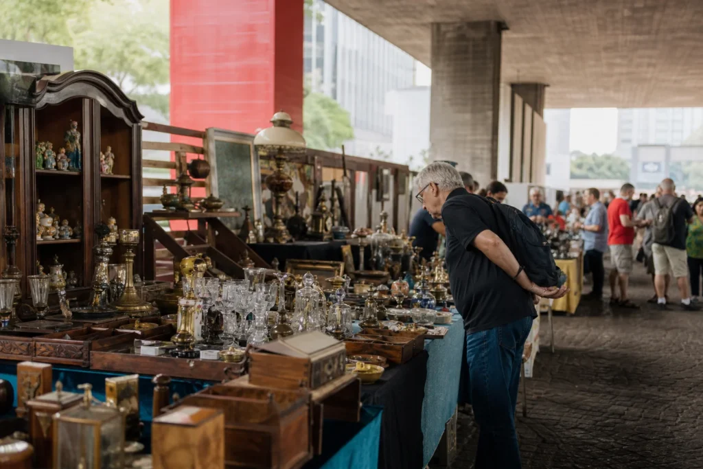 shoppers browsing antique and vintage market stalls at Feira de Antiguidades do MASP in Brazil
