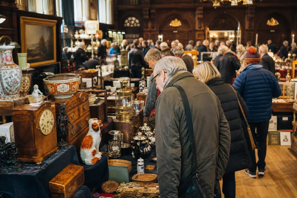 shoppers browsing antique and vintage market stalls at Guildhall Antique Fairs in United Kingdom