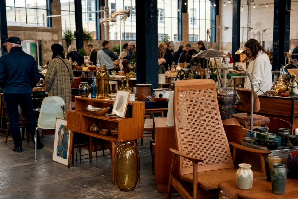 shoppers browsing antique and vintage market stalls at Hackney Flea Market in London