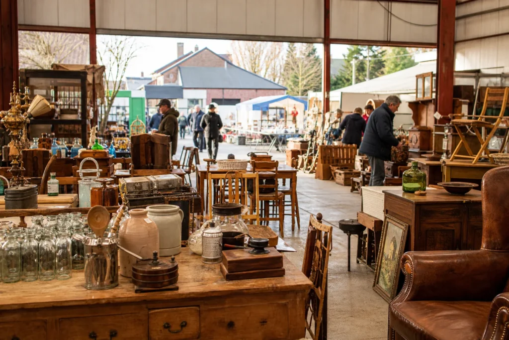 shoppers browsing antique and vintage market stalls at Hallenflohmarkt Hauset in Belgium