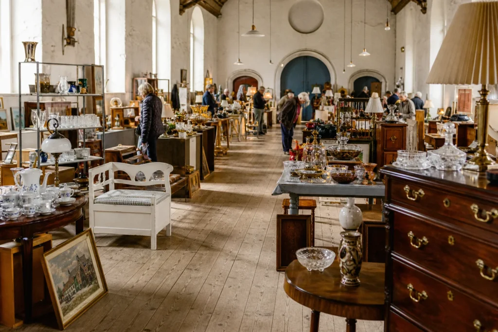 shoppers browsing antique and vintage market stalls at Haughus Gods, Vintage, Antik & Lopper in Denmark