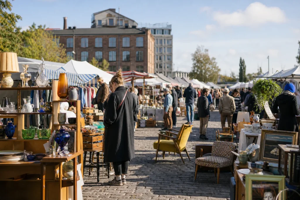 shoppers browsing antique and vintage market stalls at Hietalahti Flea Market in Finland