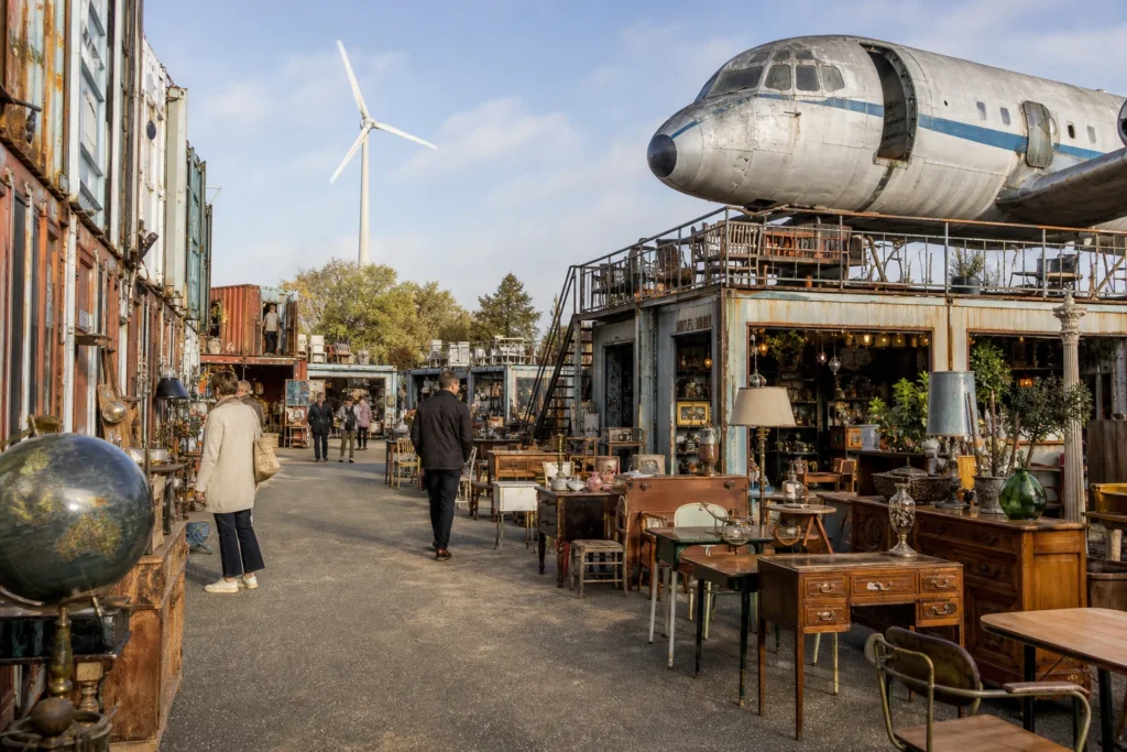 shoppers browsing antique and vintage market stalls at Le Village des Brocanteurs in France
