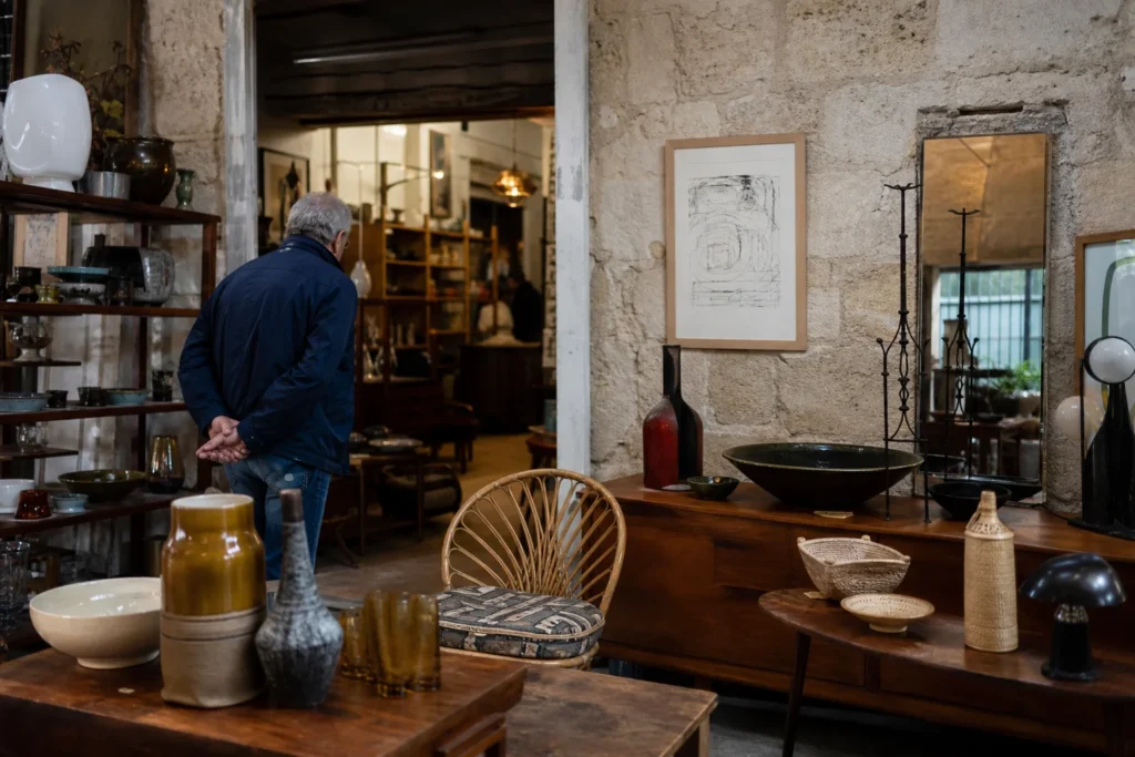 shoppers browsing antique and vintage market stalls at Les Brocanteurs du Passage Saint Michel in France