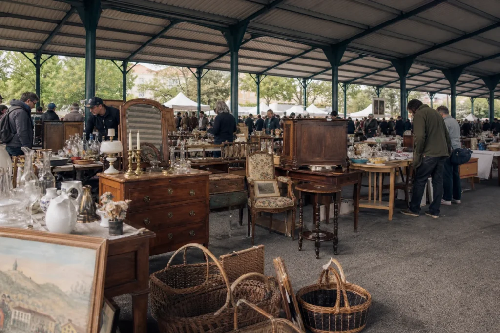 shoppers browsing antique and vintage market stalls at Les Puces de Quintaou in France
