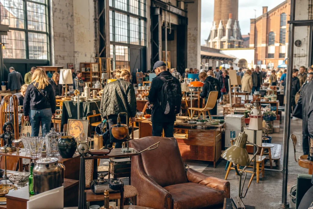 shoppers browsing antique and vintage market stalls at Loppemarked i Tap 1 in Copenhagen