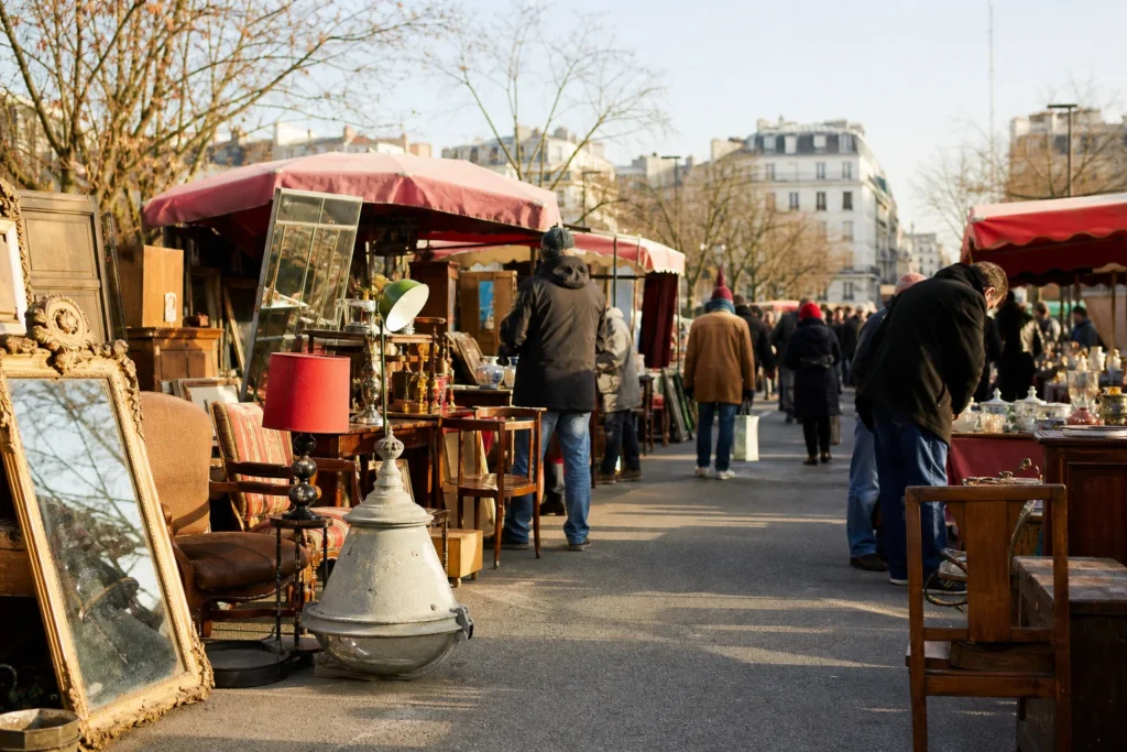 shoppers browsing antique and vintage market stalls at Marché aux Puces de Montreuil in Paris