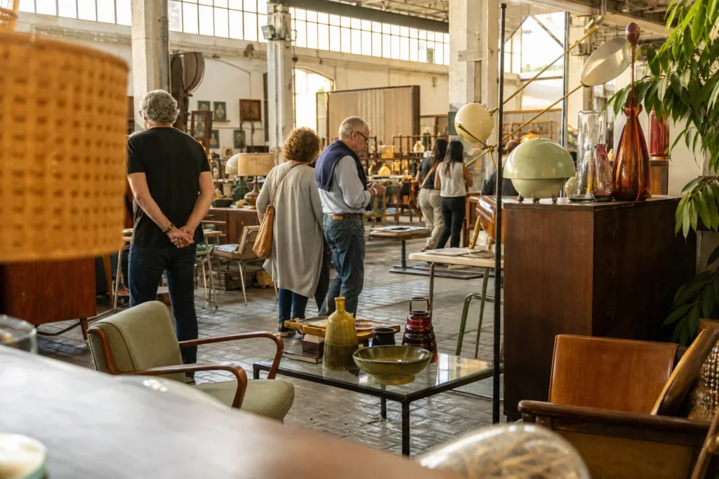 shoppers browsing antique and vintage market stalls at Mercantic Barcelona in Spain