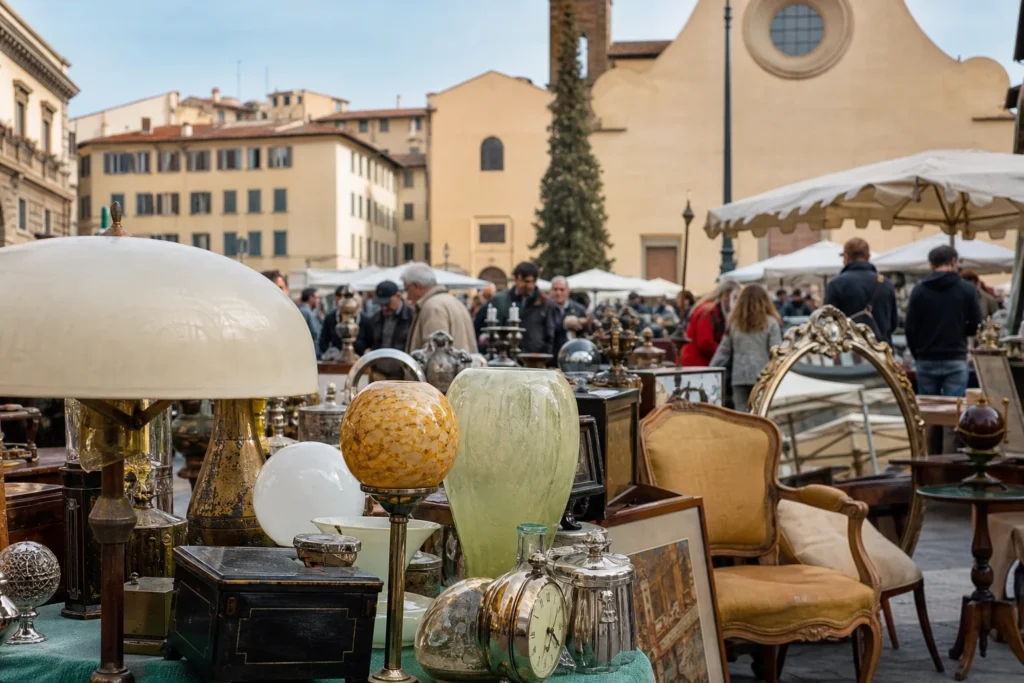shoppers browsing antique and vintage market stalls at Mercato di Santo Spirito in Florence, Italy