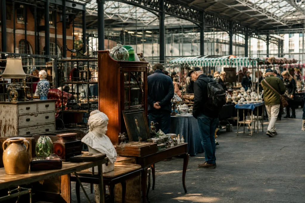 shoppers browsing antique and vintage market stalls at Old Spitalfields Market in London