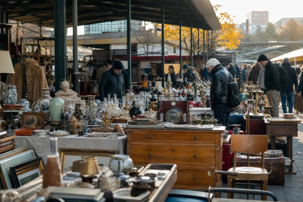 shoppers browsing antique and vintage market stalls at Ostbahnhof Flohmarkt in Berlin, Germany