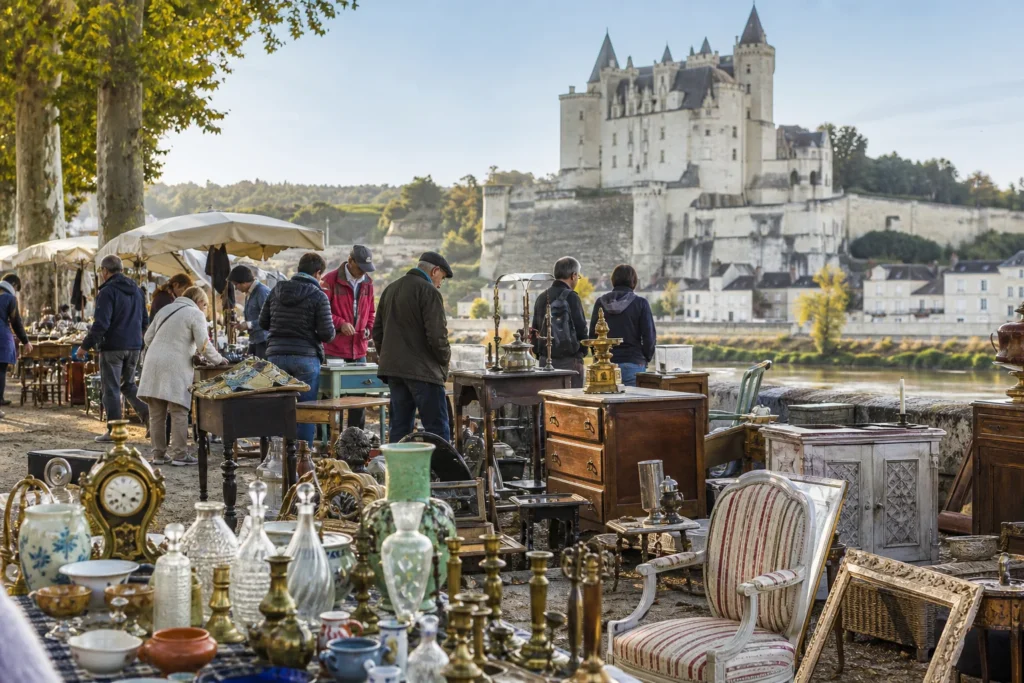 shoppers browsing antique and vintage market stalls at Puces de Montsoreau in France