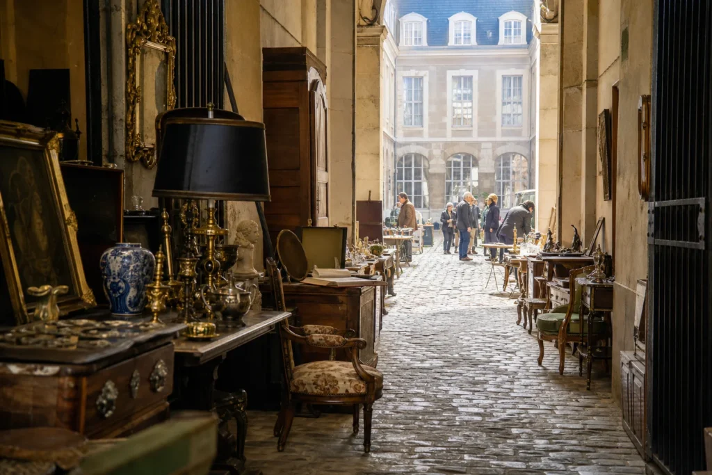 shoppers browsing antique and vintage market stalls at Quartier des Antiquaires de la Geôle et du Bailliage in France