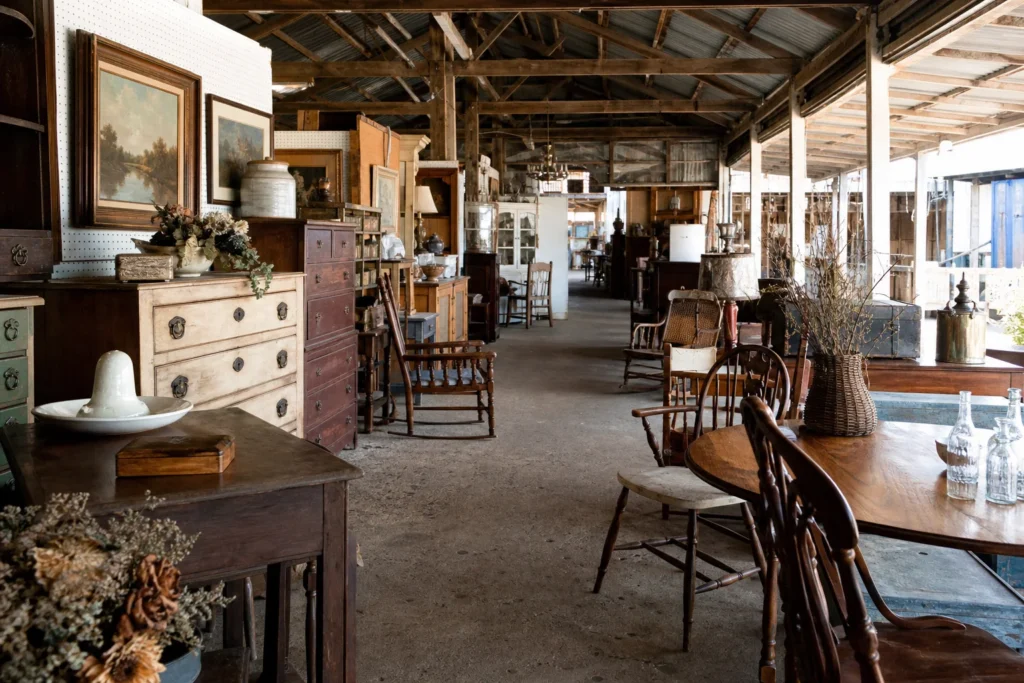 shoppers browsing antique and vintage market stalls at Riverside Furniture Antiques Flea Market in Mississippi