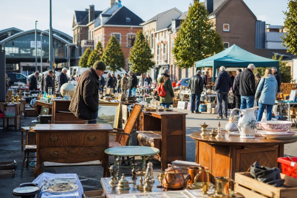 shoppers browsing antique and vintage market stalls at Rommelmarkt Lokeren in Belgium