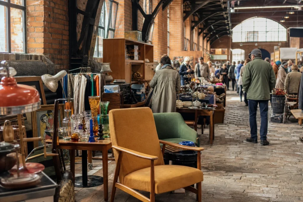 shoppers browsing antique and vintage market stalls at Spīķeri Flea Market in Latvia