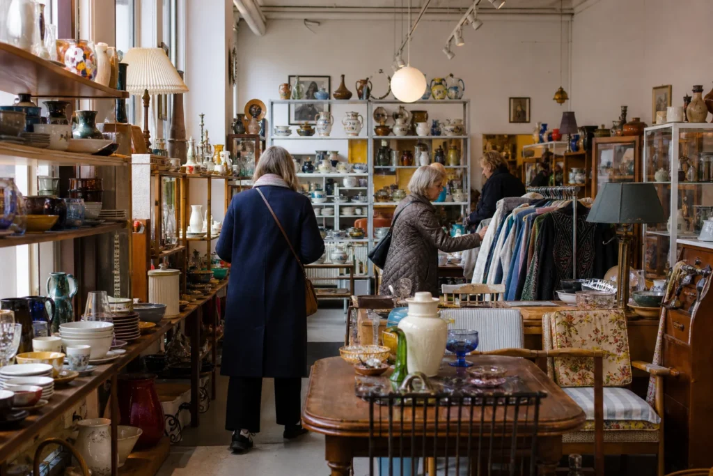 shoppers browsing antique and vintage market stalls at Svalernes Loppemarked in Copenhagen