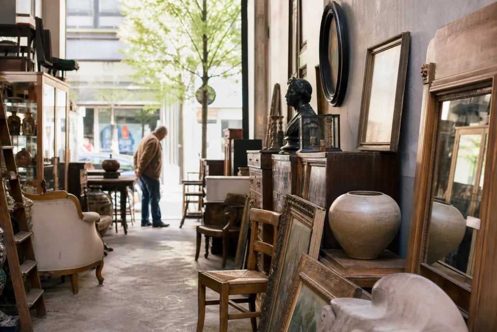 shoppers browsing antique and vintage market stalls at The antique dealers of Rue Haute and Rue Blaes in Belgium