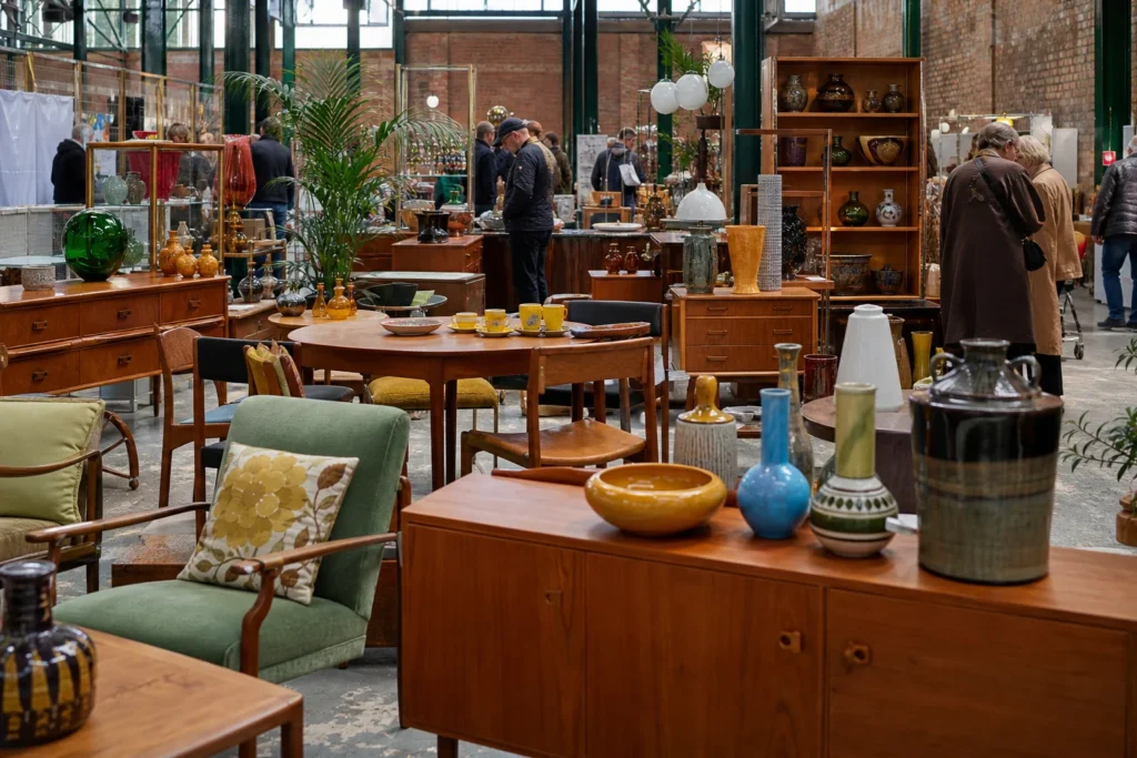 shoppers browsing antique and vintage market stalls at The Vintage Home Show Manchester in United Kingdom