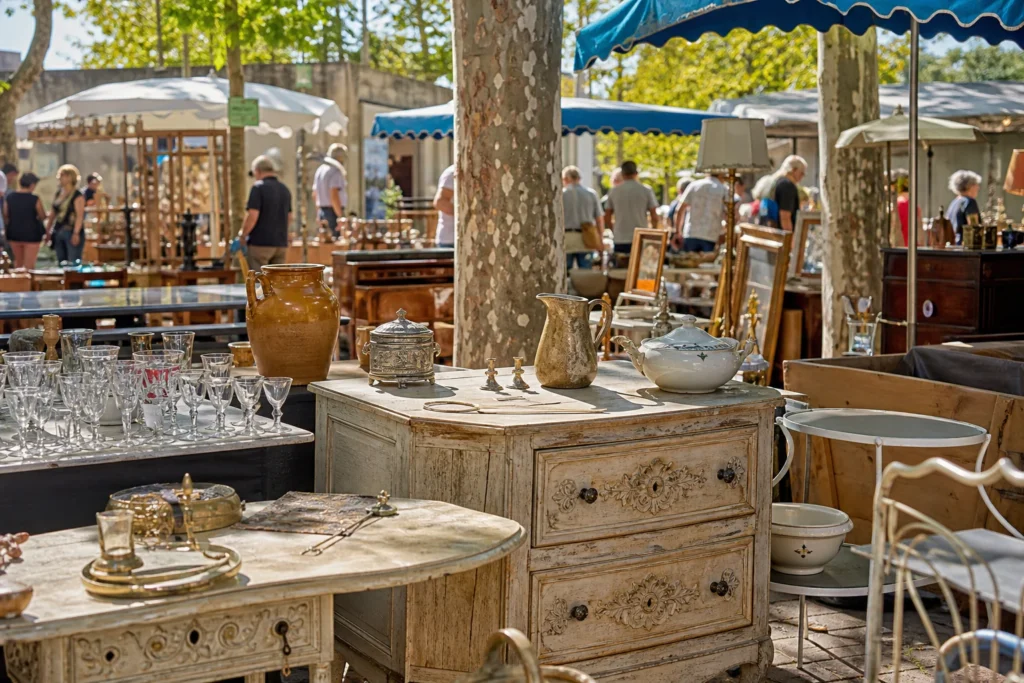 shoppers browsing antique and vintage market stalls at Uzès flea market in Provence