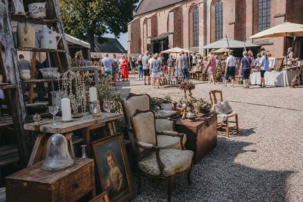 shoppers browsing antique and vintage market stalls at Vive la France Brocantemarkt in Netherlands
