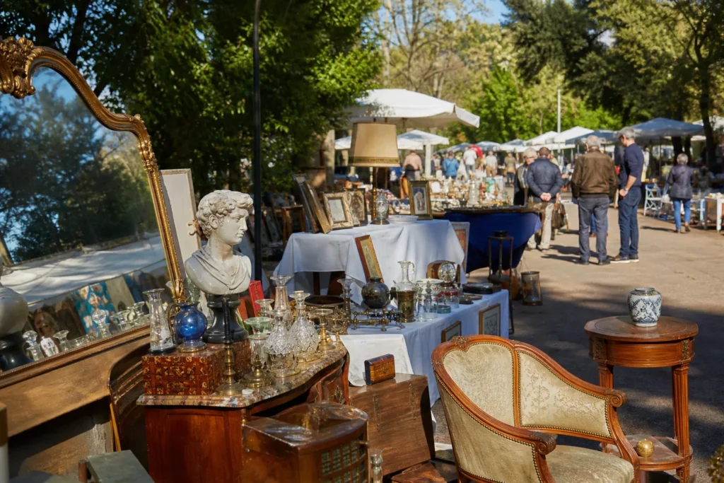 shoppers browsing antique and vintage market stalls at Mercatino di Villa Glori a Roma in Italy